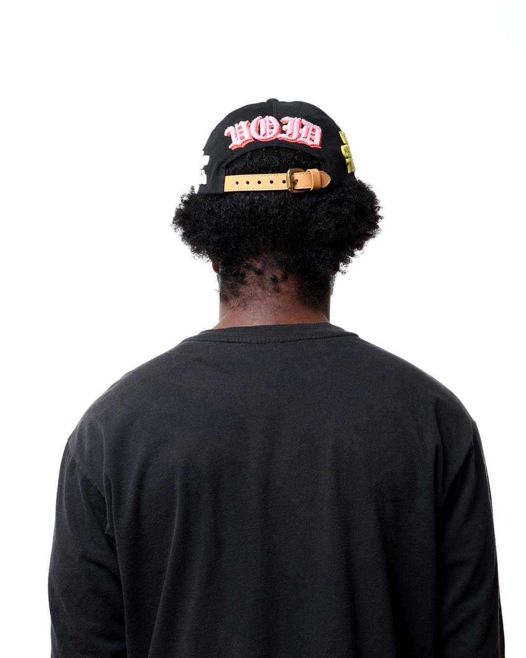 Person wearing a black cap with red text on a white background