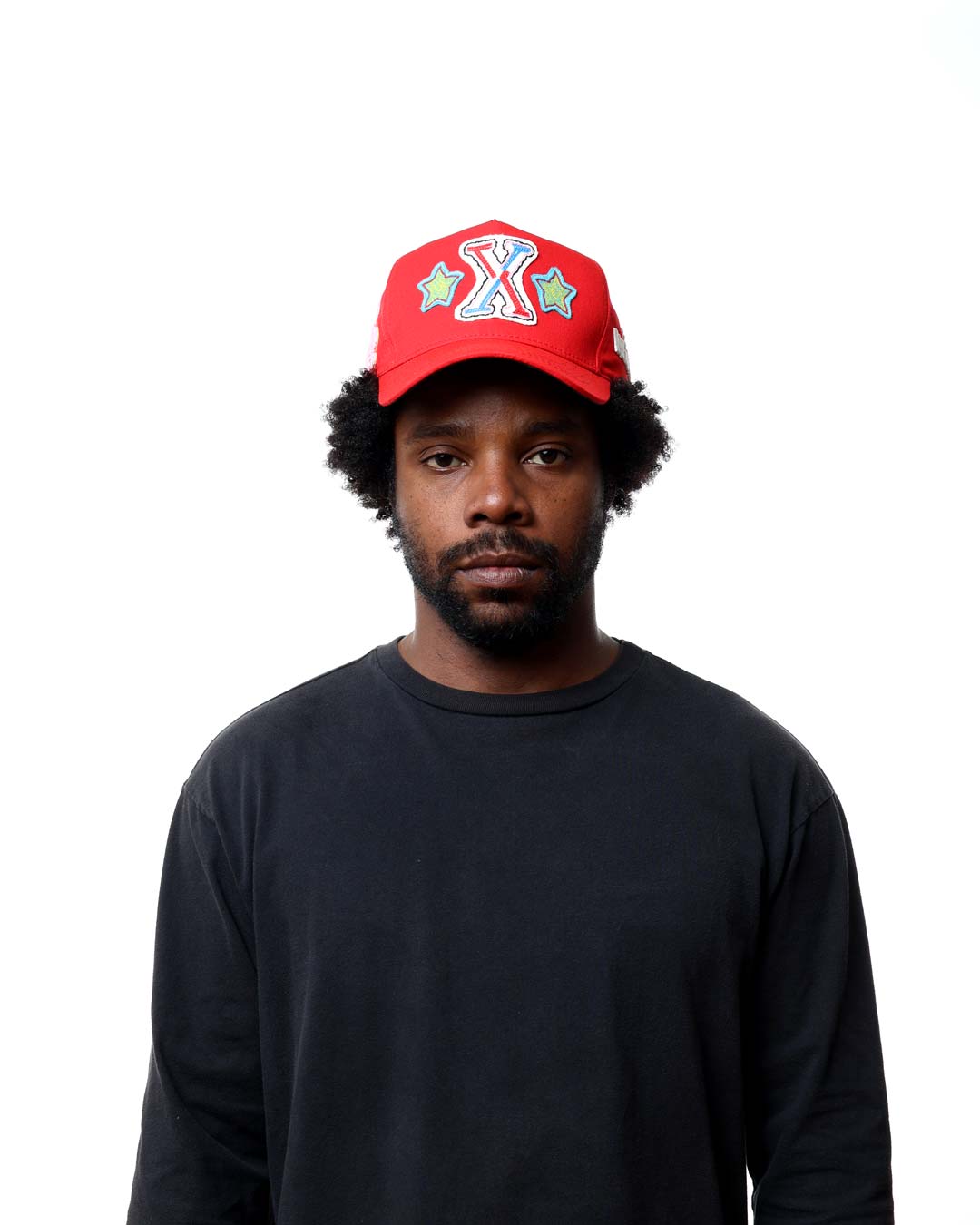 Man wearing a red cap with a colorful design on a white background
