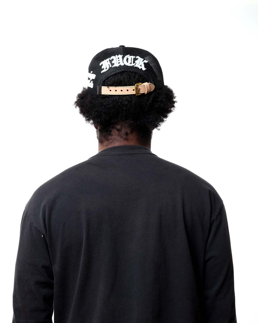 Person wearing a black cap with white text on the back, facing away from the camera.