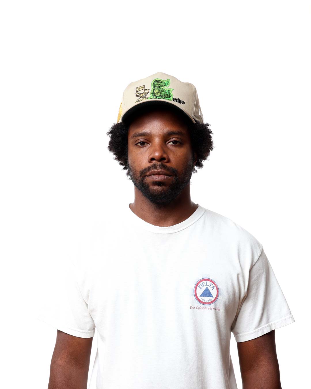 Man wearing a cap and white t-shirt with a logo on a white background
