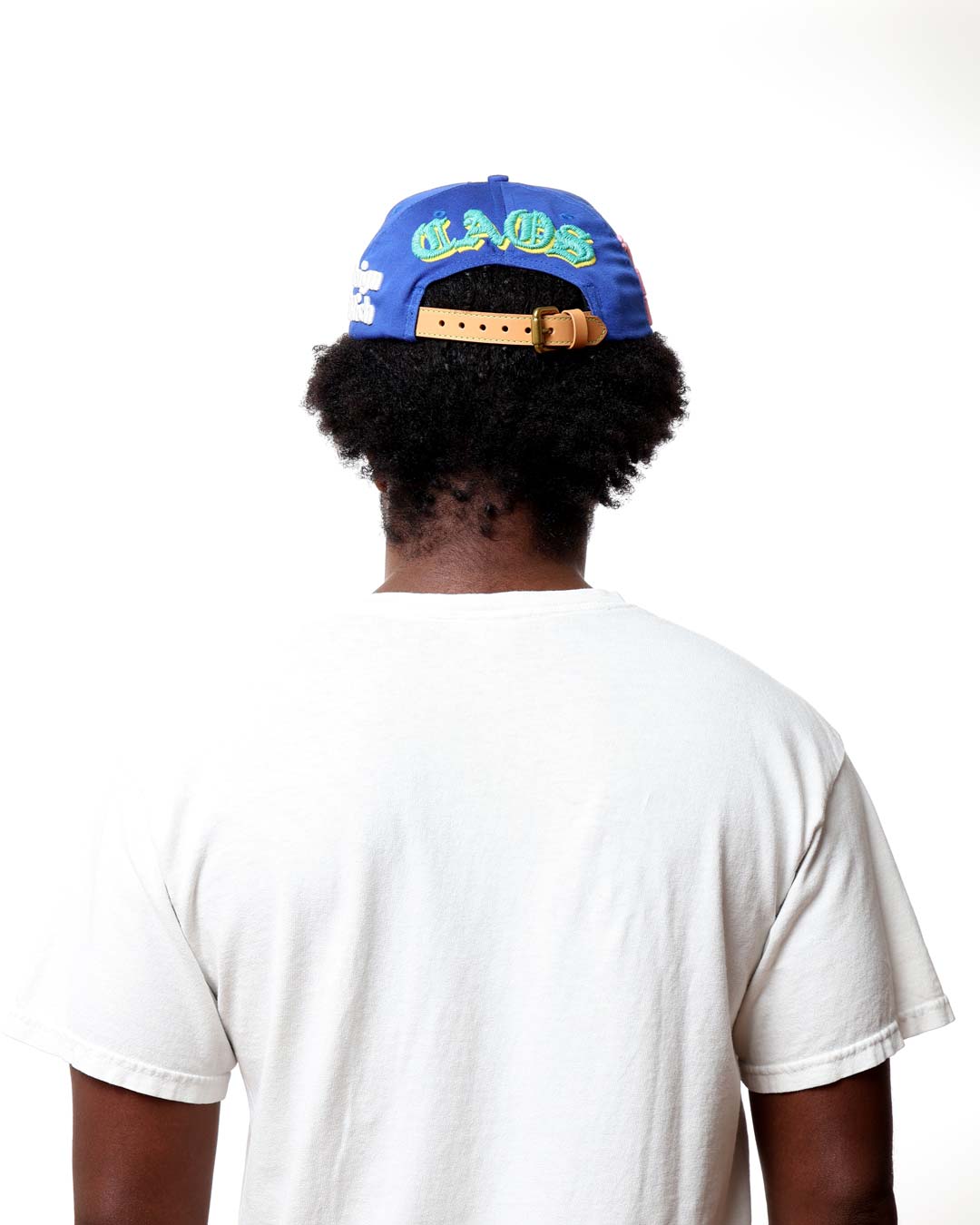 Person wearing a blue cap with text on the back, facing away from the camera.