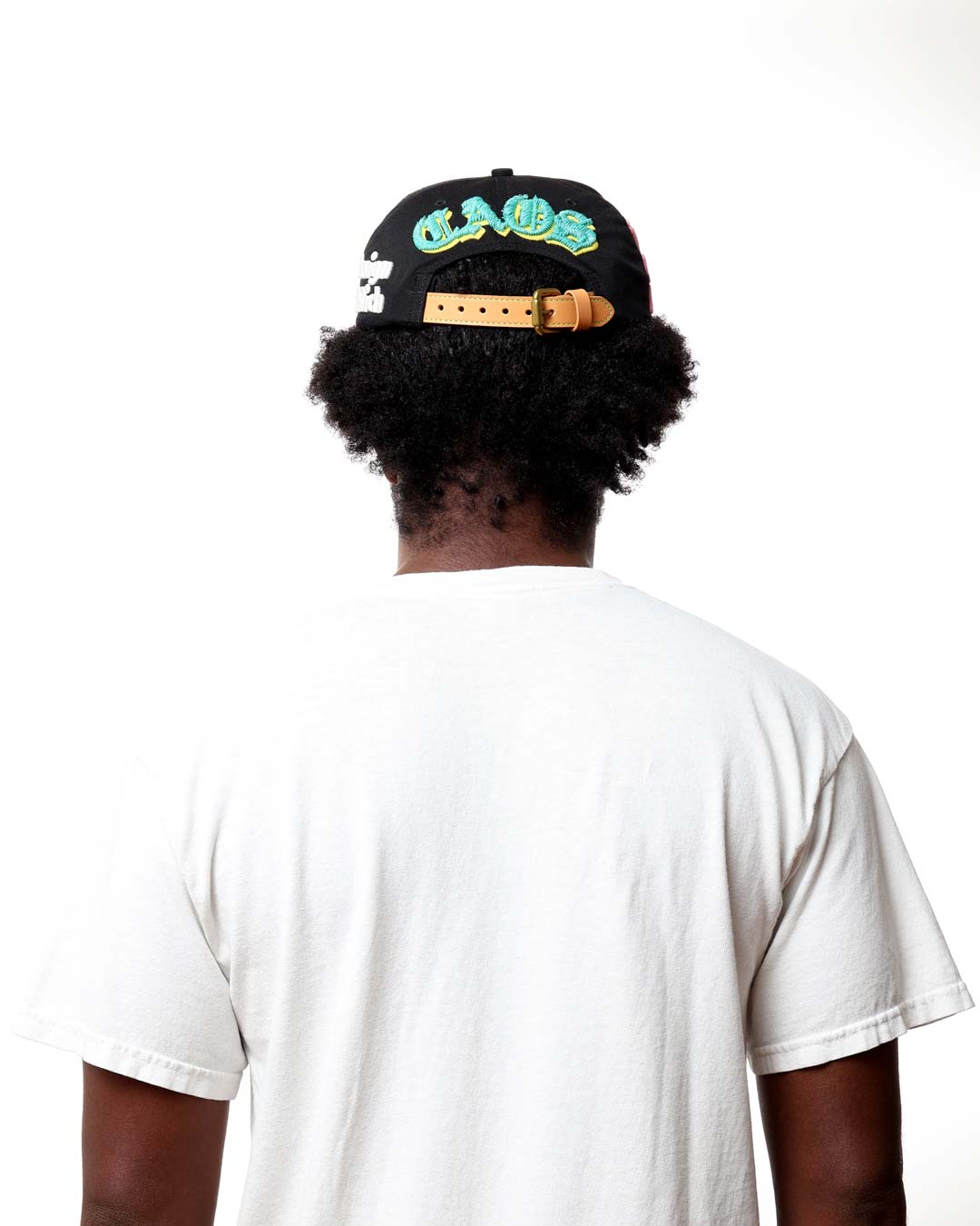 Person wearing a black cap with colorful text on a white background