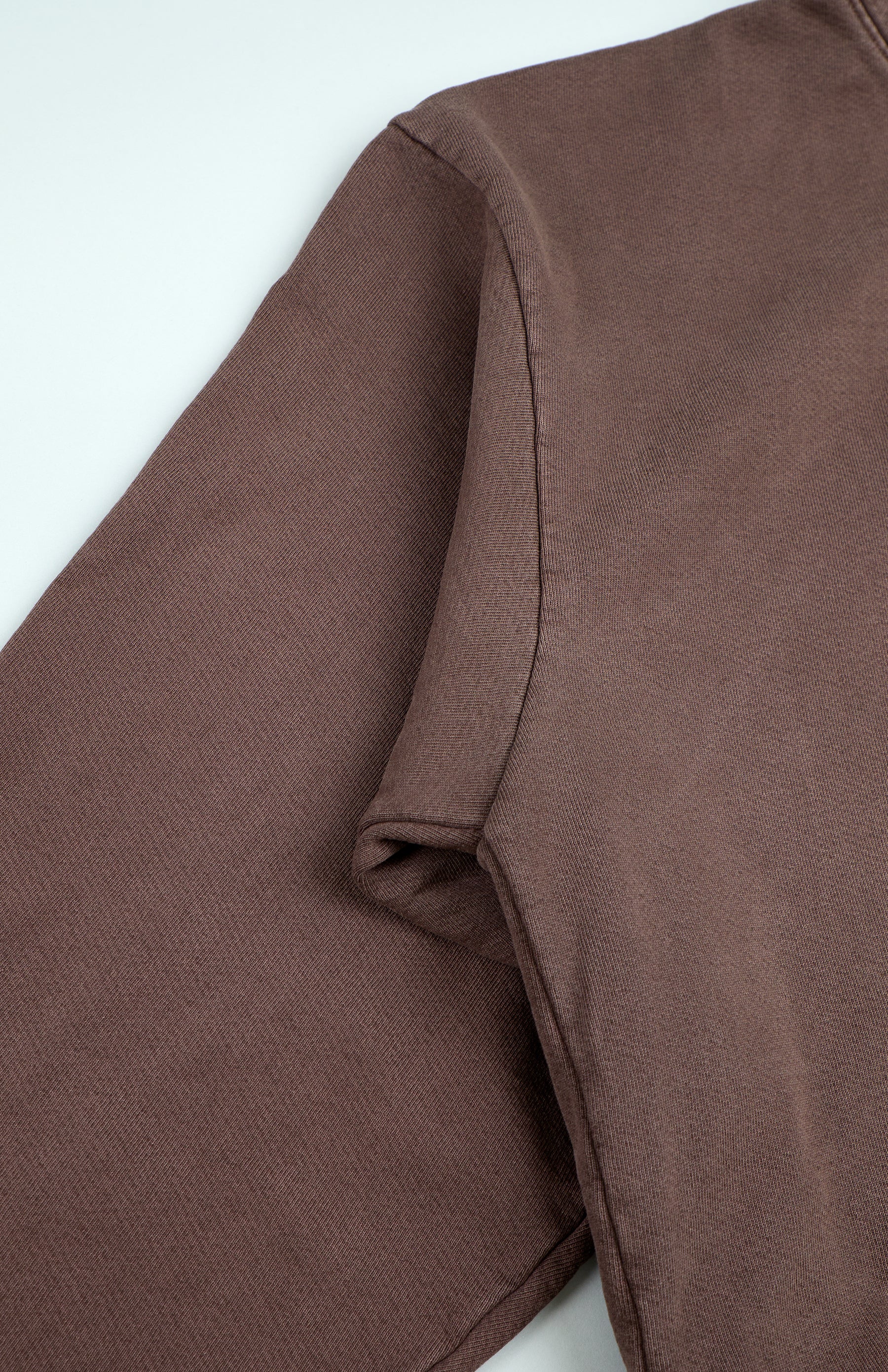 Brown long-sleeve shirt close-up.