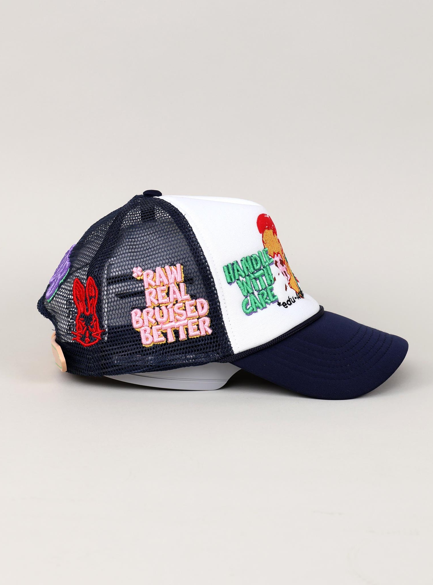 Trucker hat with embroidered patches and text.