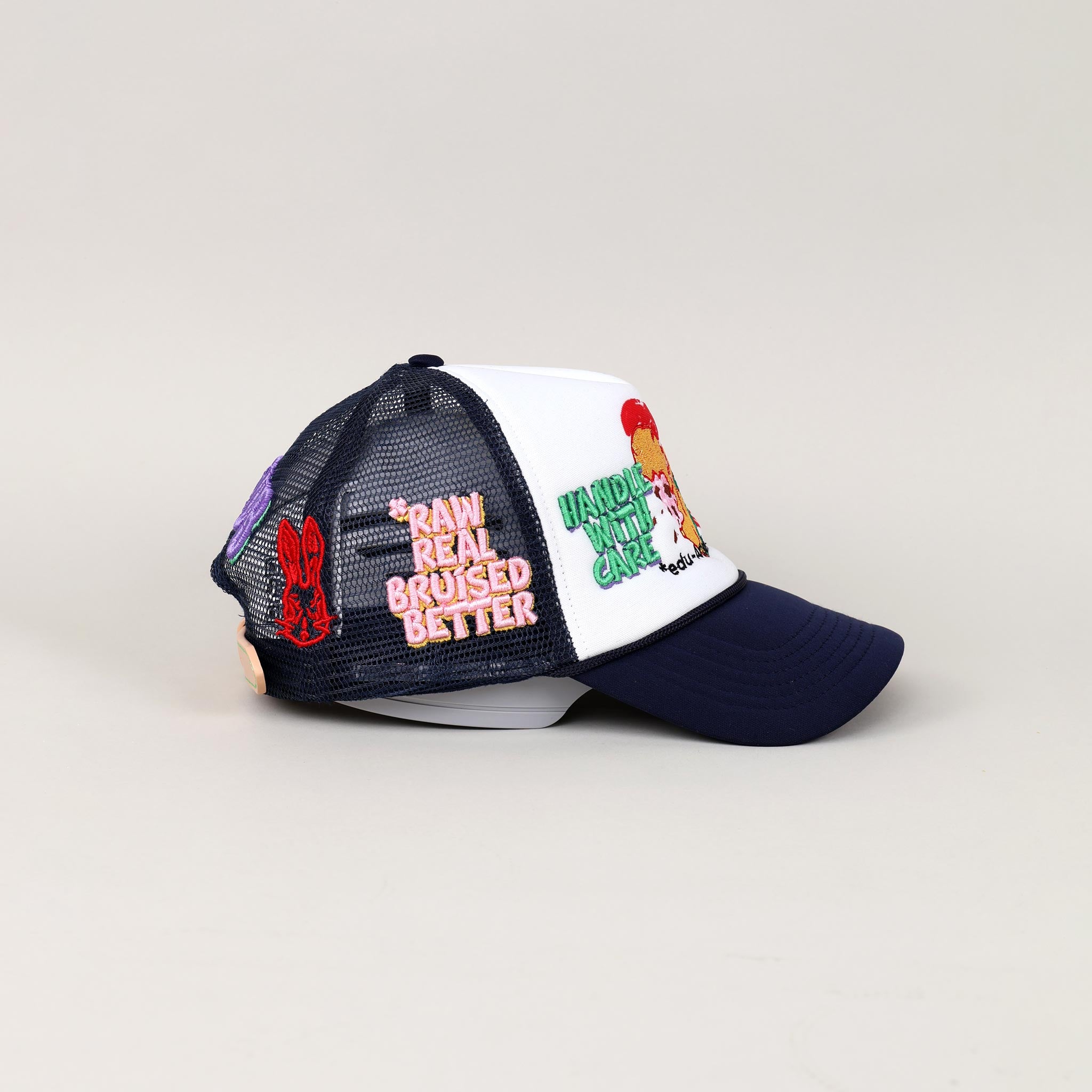 Trucker hat with embroidered patches and text.