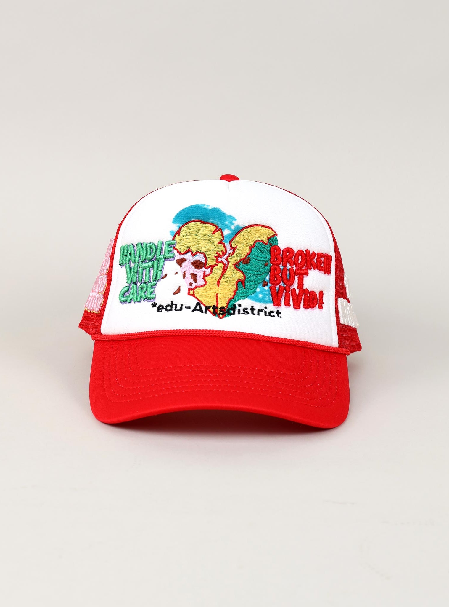 Red and white cap with embroidered design and text.
