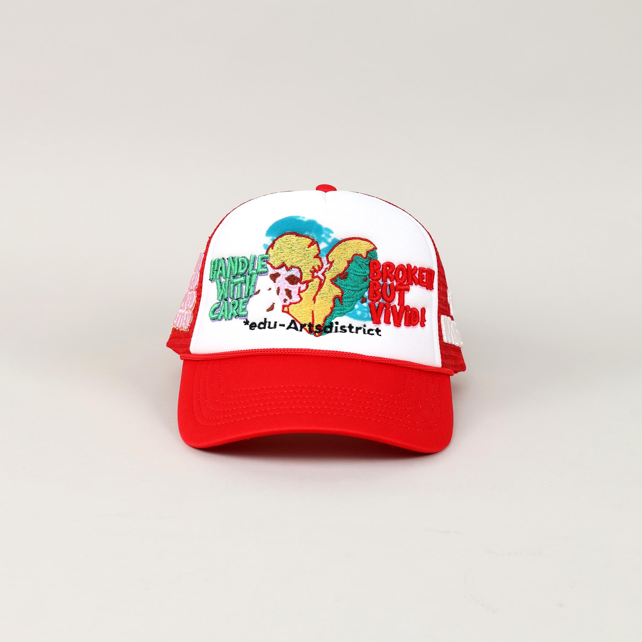 Red and white cap with embroidered design and text.