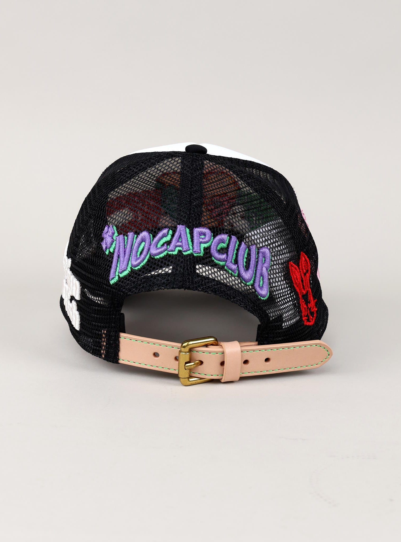 Black mesh cap with "NOCAPCLUB" text, colorful patches.