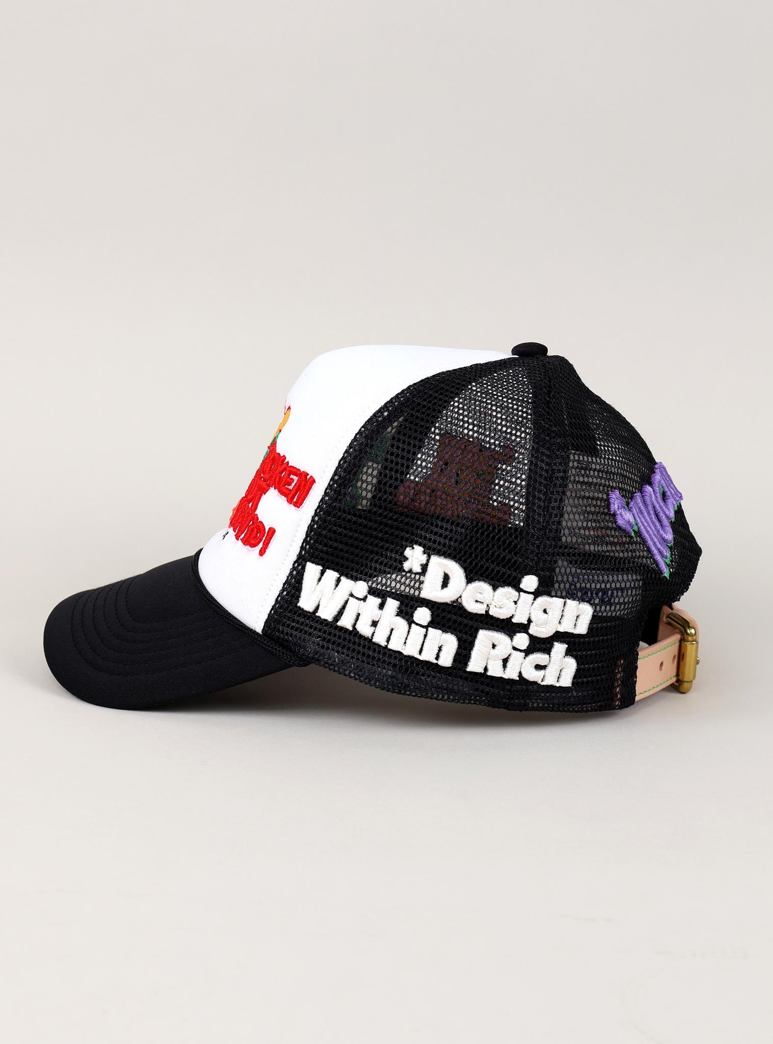 Black and white mesh cap with embroidered text.