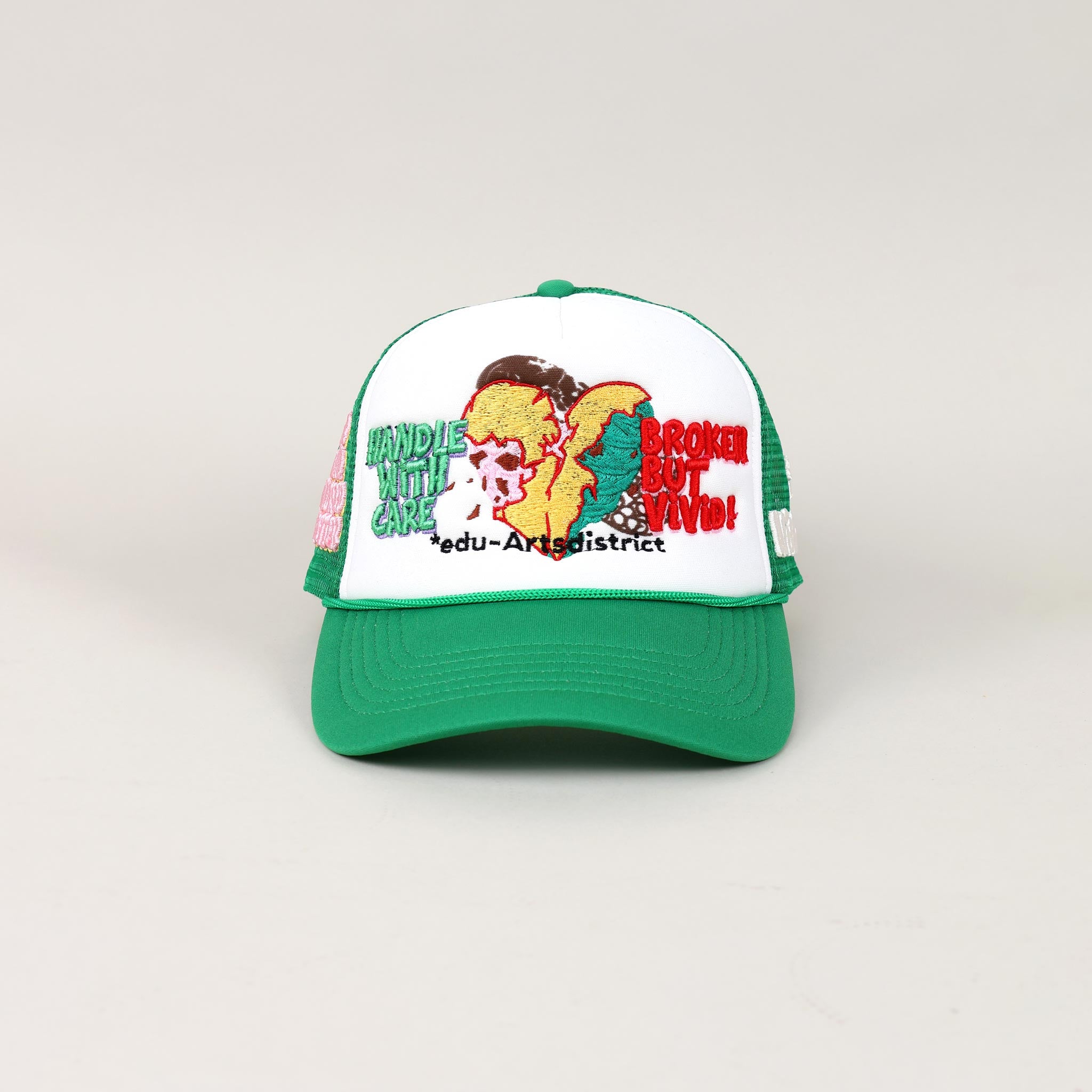 Green and white cap with embroidered text and designs.
