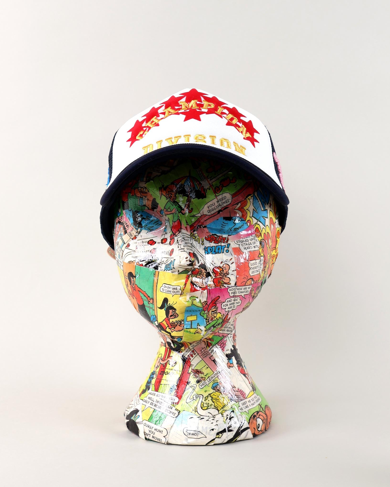 Comic-themed mannequin head with a colorful cap.
