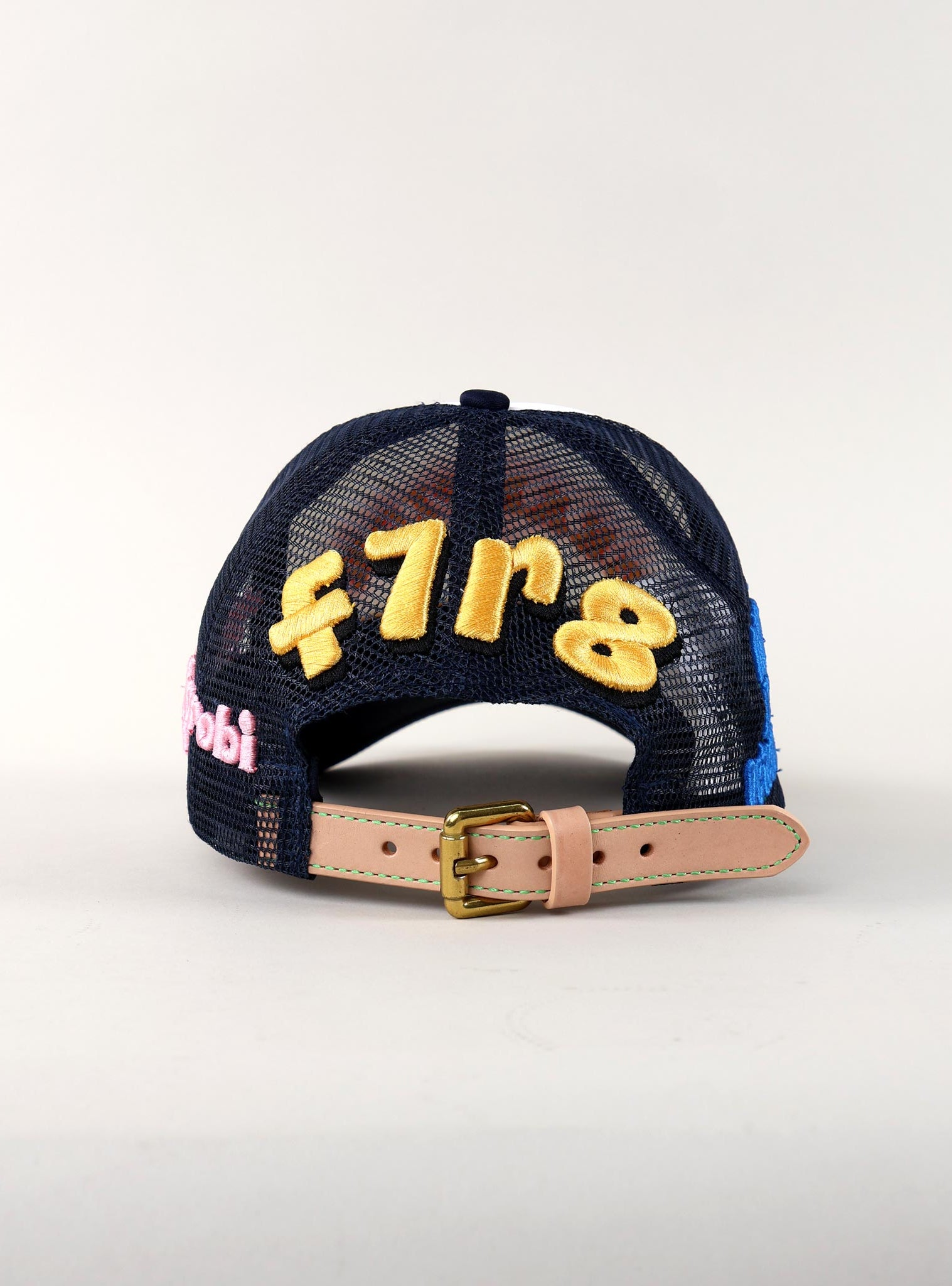 Back of a navy mesh cap with embroidery.
