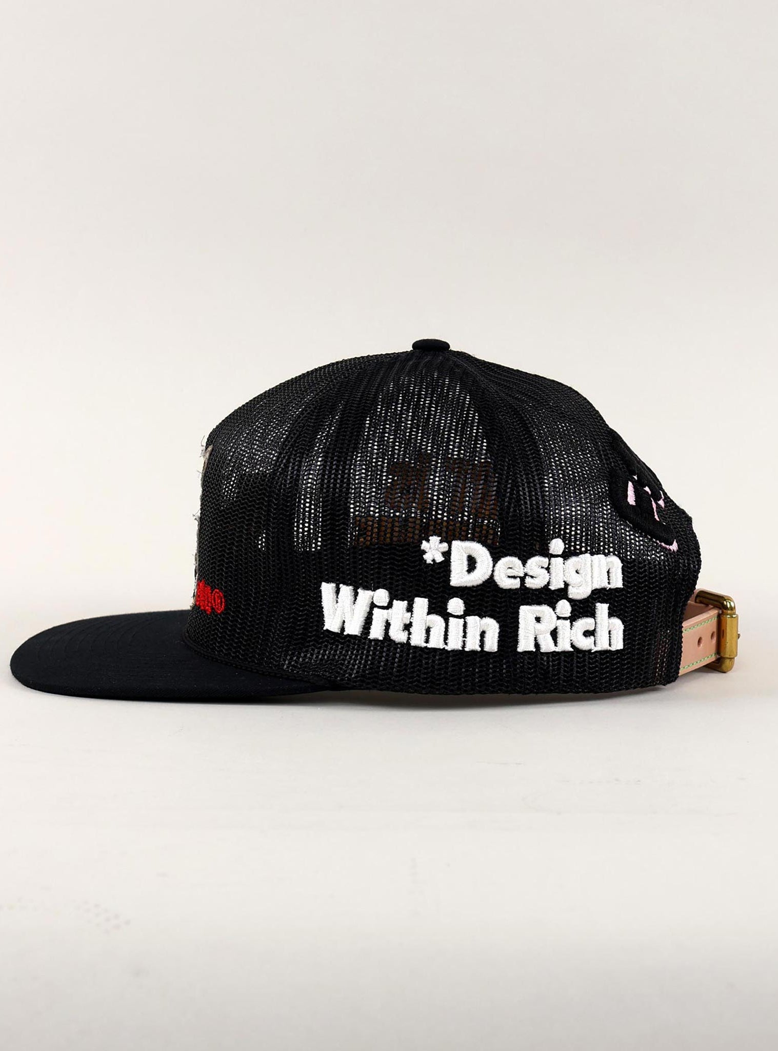 Black and white trucker hat with "Design Within Rich."