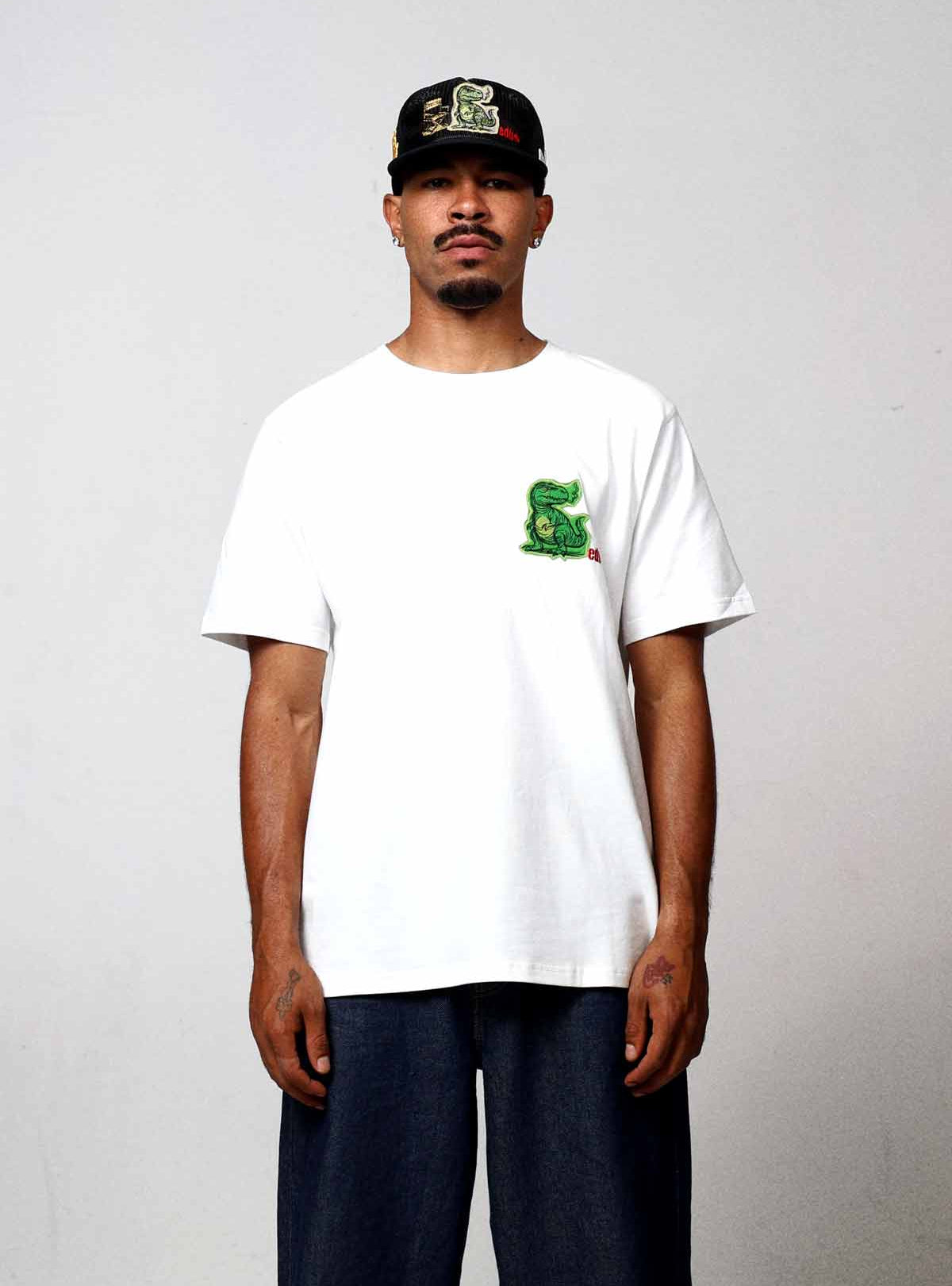 Man wearing white t-shirt with green graphic.