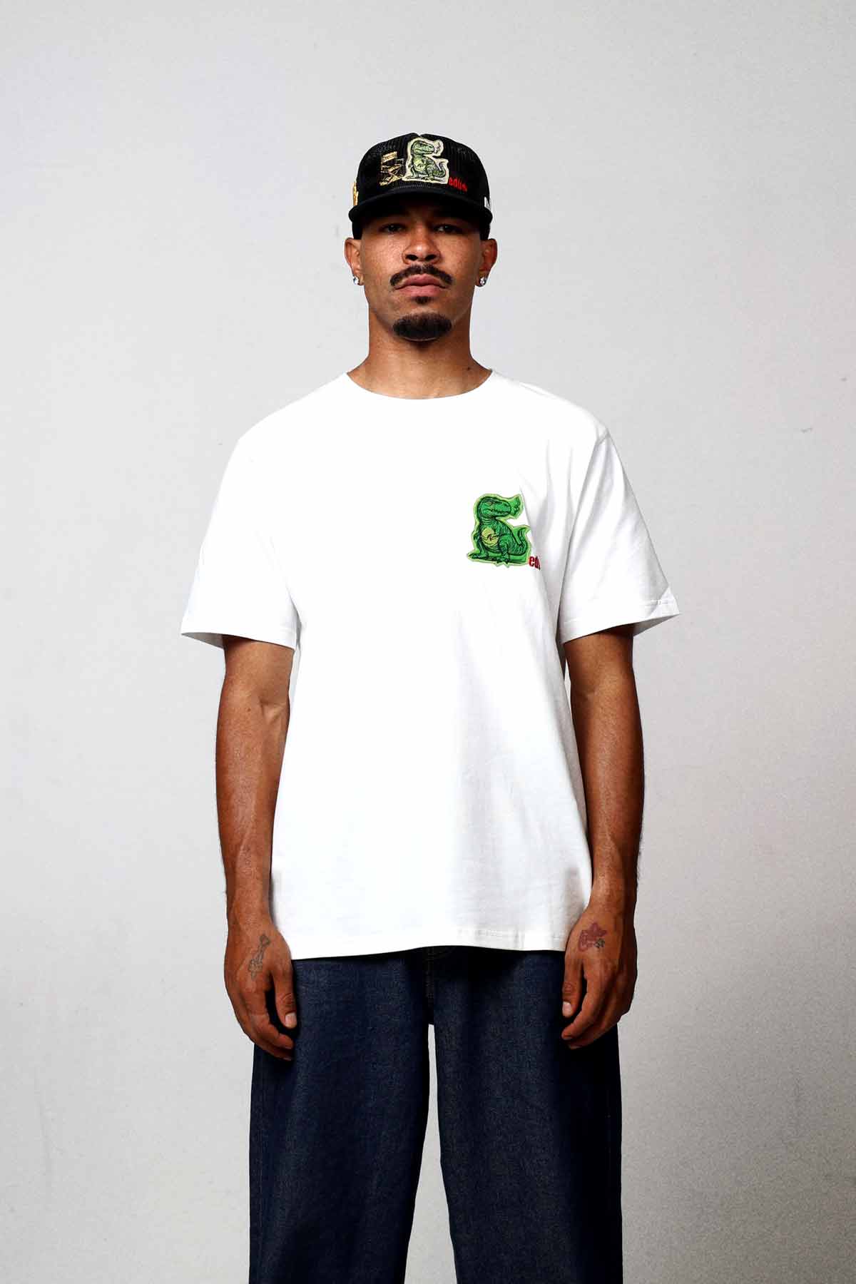 Man wearing white t-shirt with green graphic.