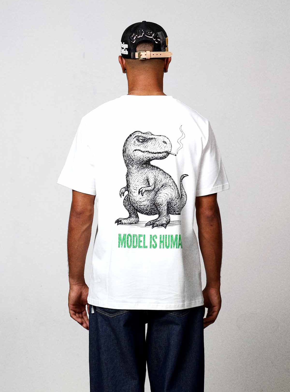 Man wearing dinosaur graphic t-shirt and cap.