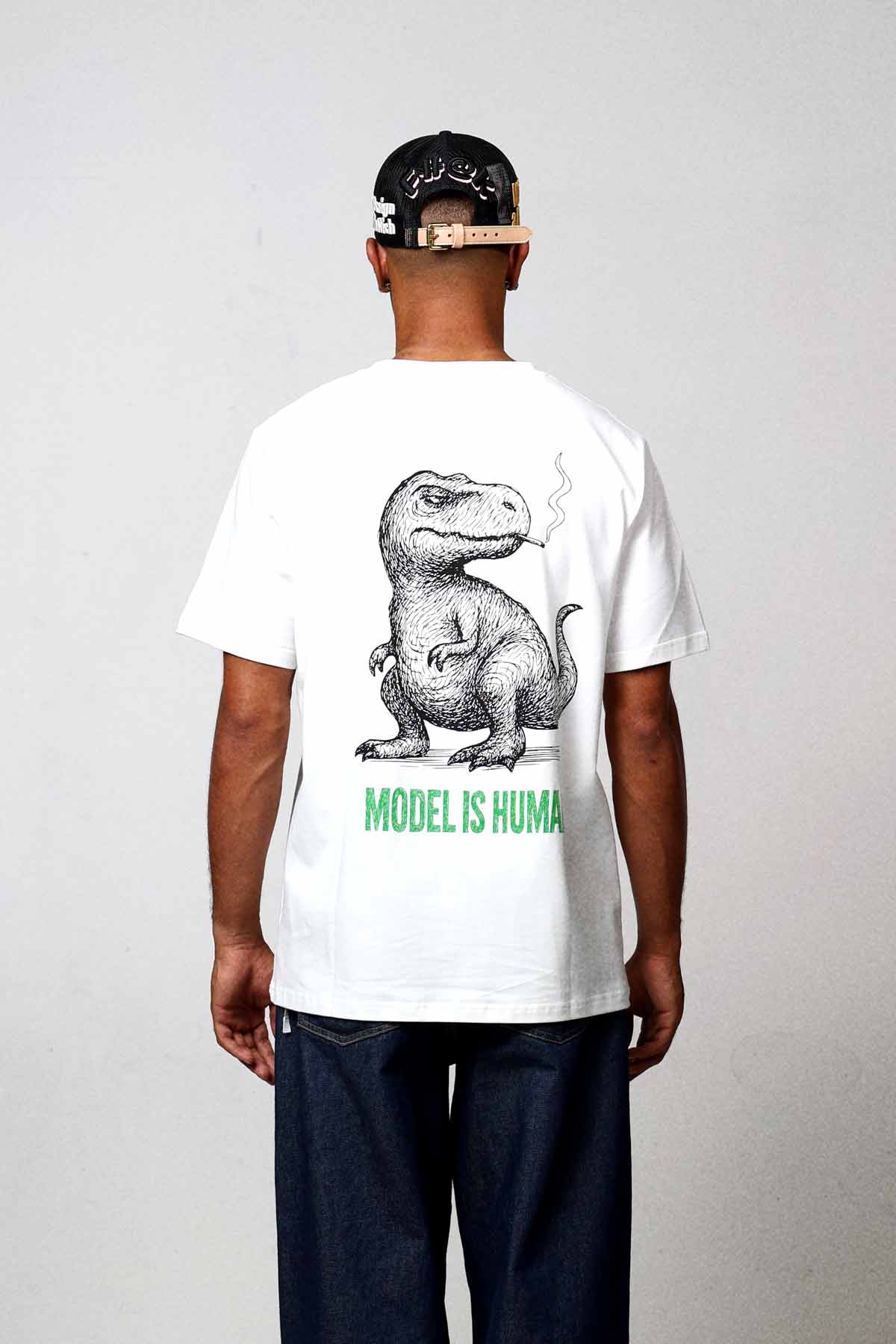 Man wearing dinosaur graphic t-shirt and cap.