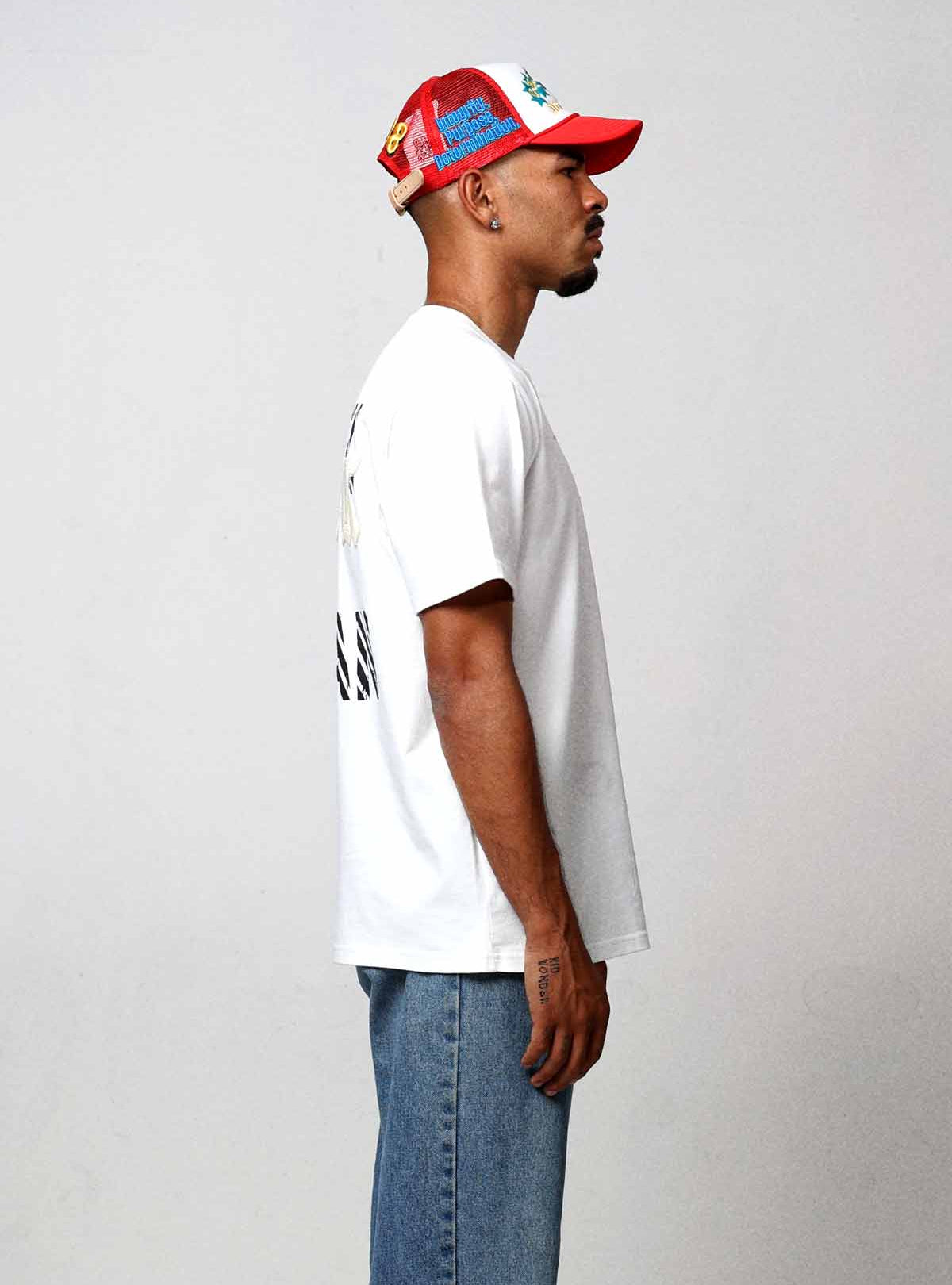Man in white shirt and jeans, side profile.