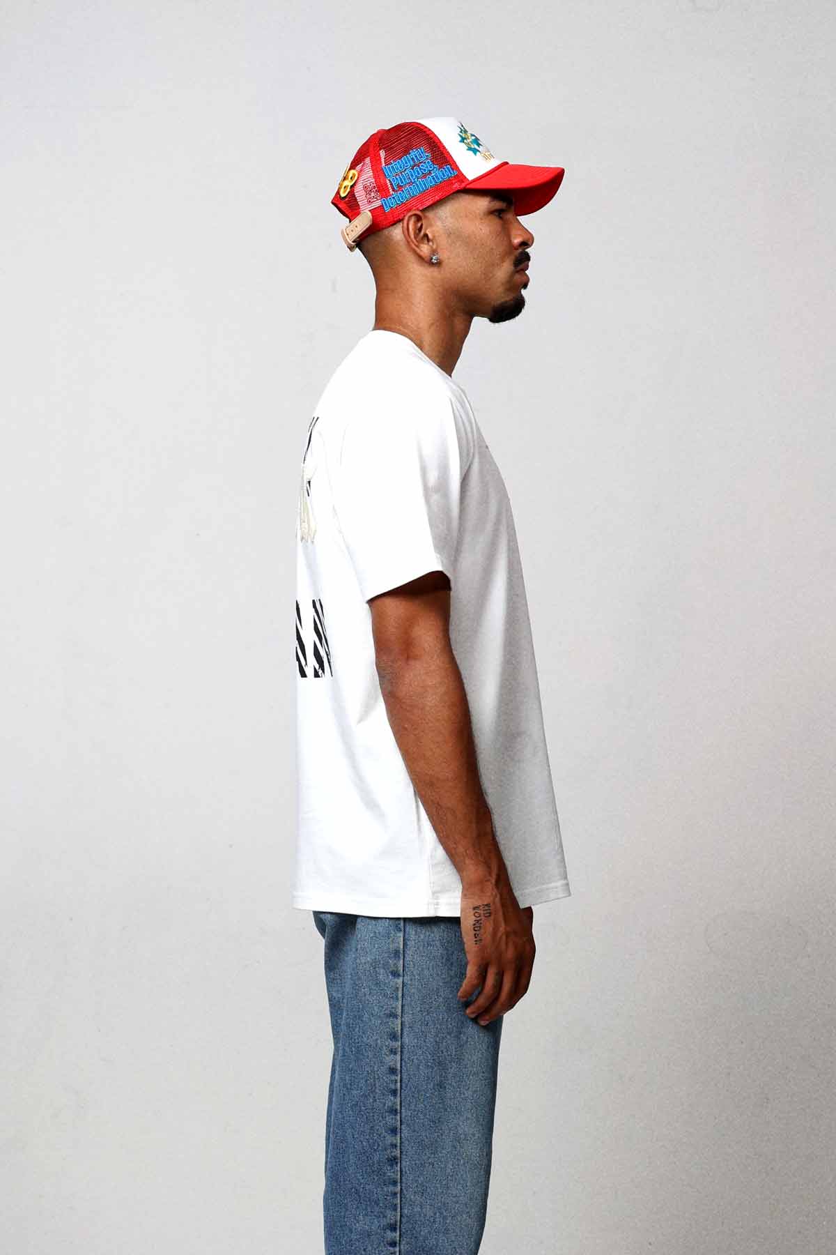 Man in white shirt and jeans, side profile.