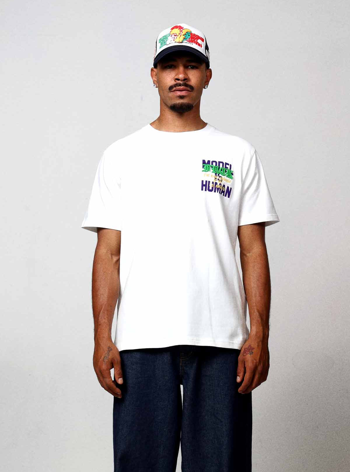 Man wearing white t-shirt and cap.