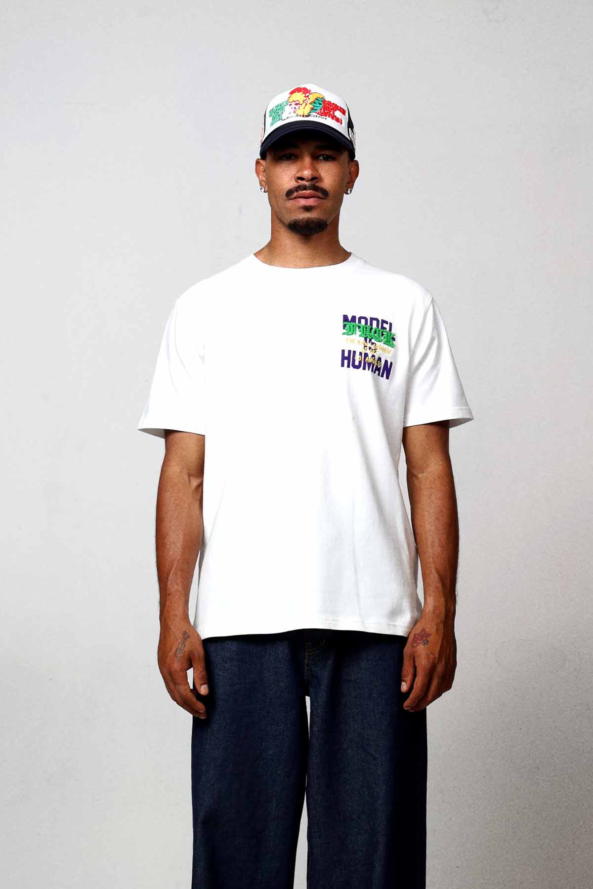 Man wearing white t-shirt and cap.