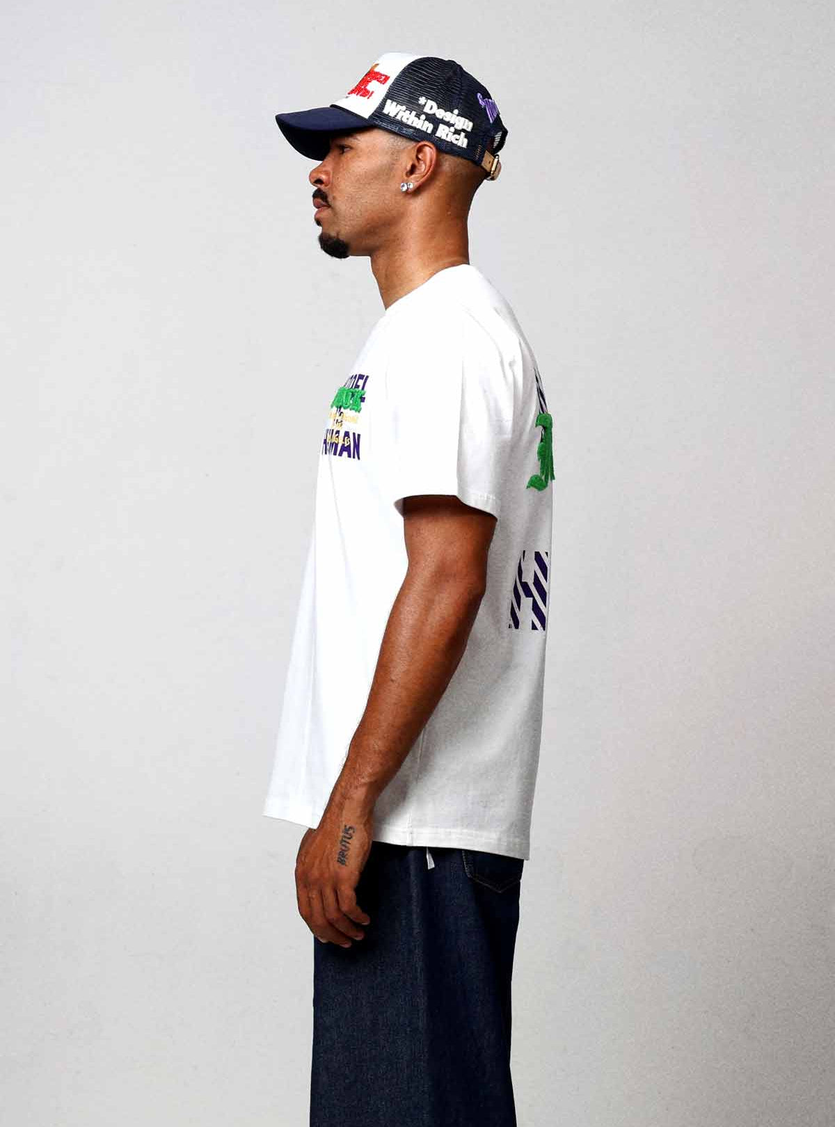 Man in white t-shirt and jeans, side view.