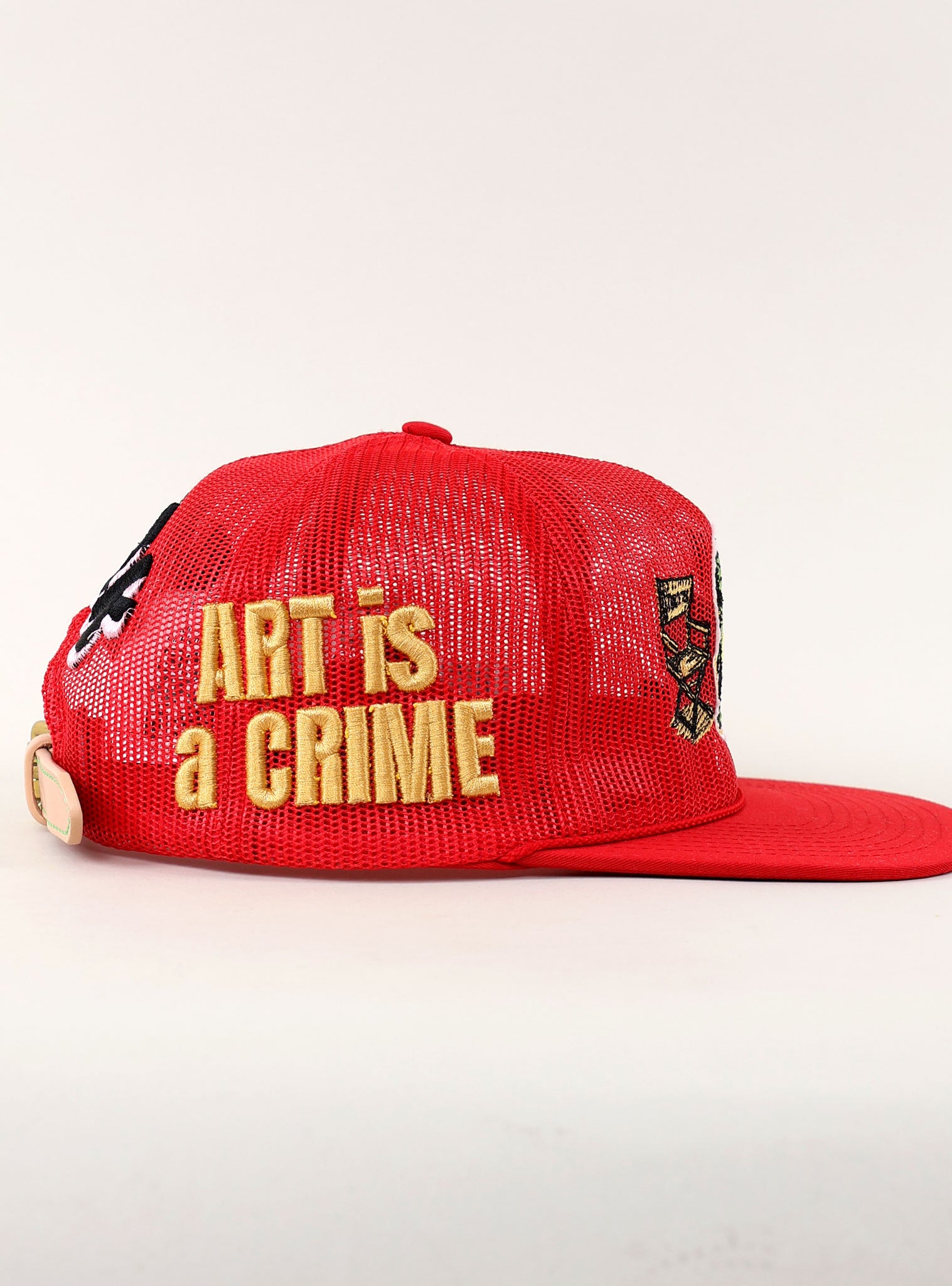 Red cap with "Art is a Crime" text.