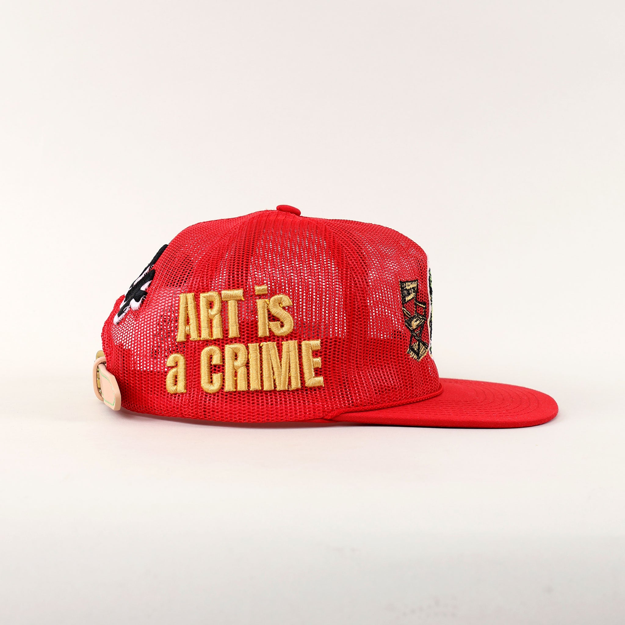Red cap with "Art is a Crime" text.