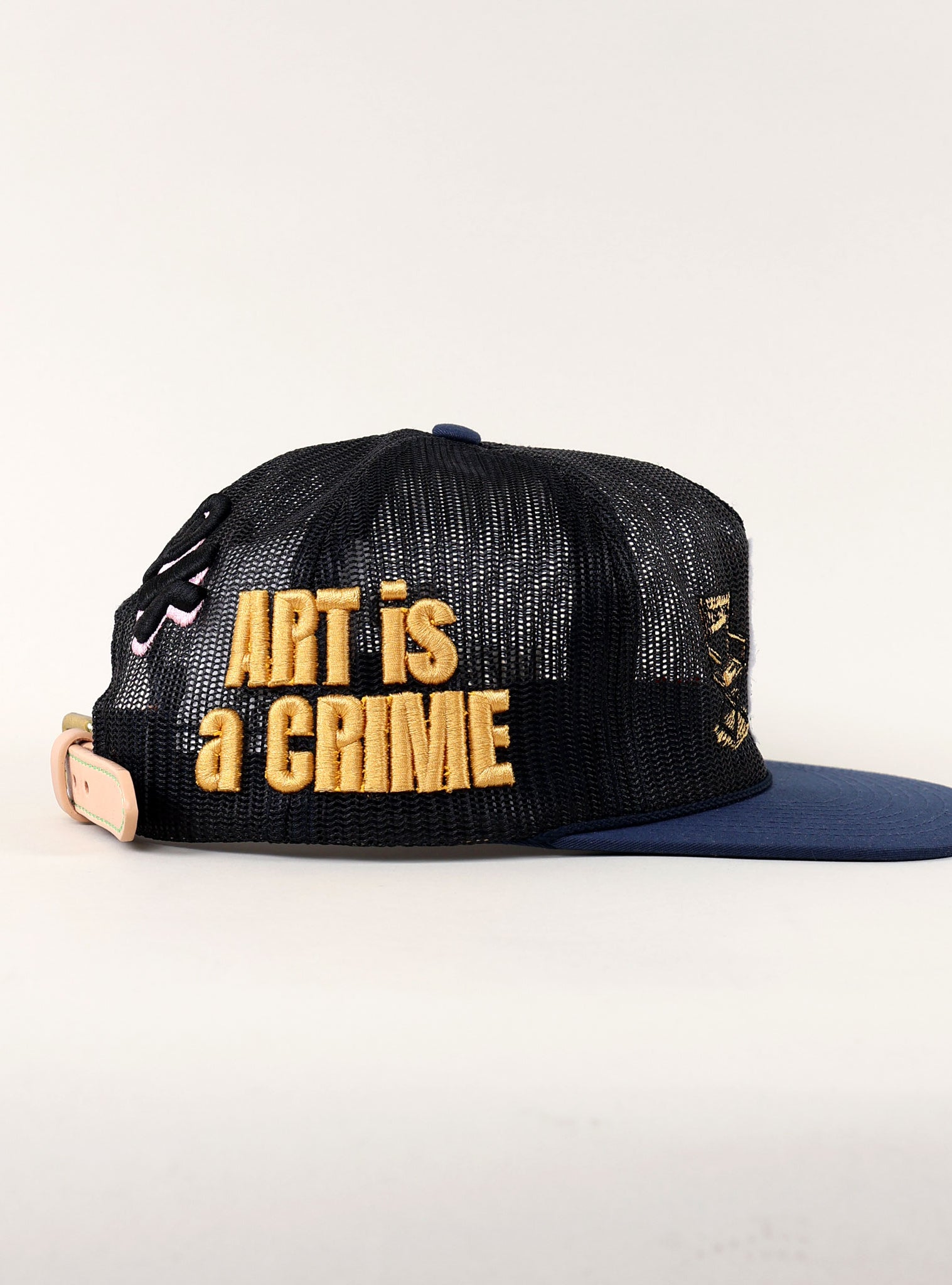 Black cap with "ART is a CRIME" text.