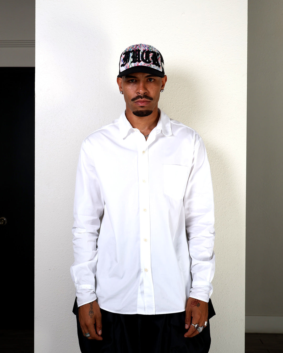 Person wearing a white shirt and black cap