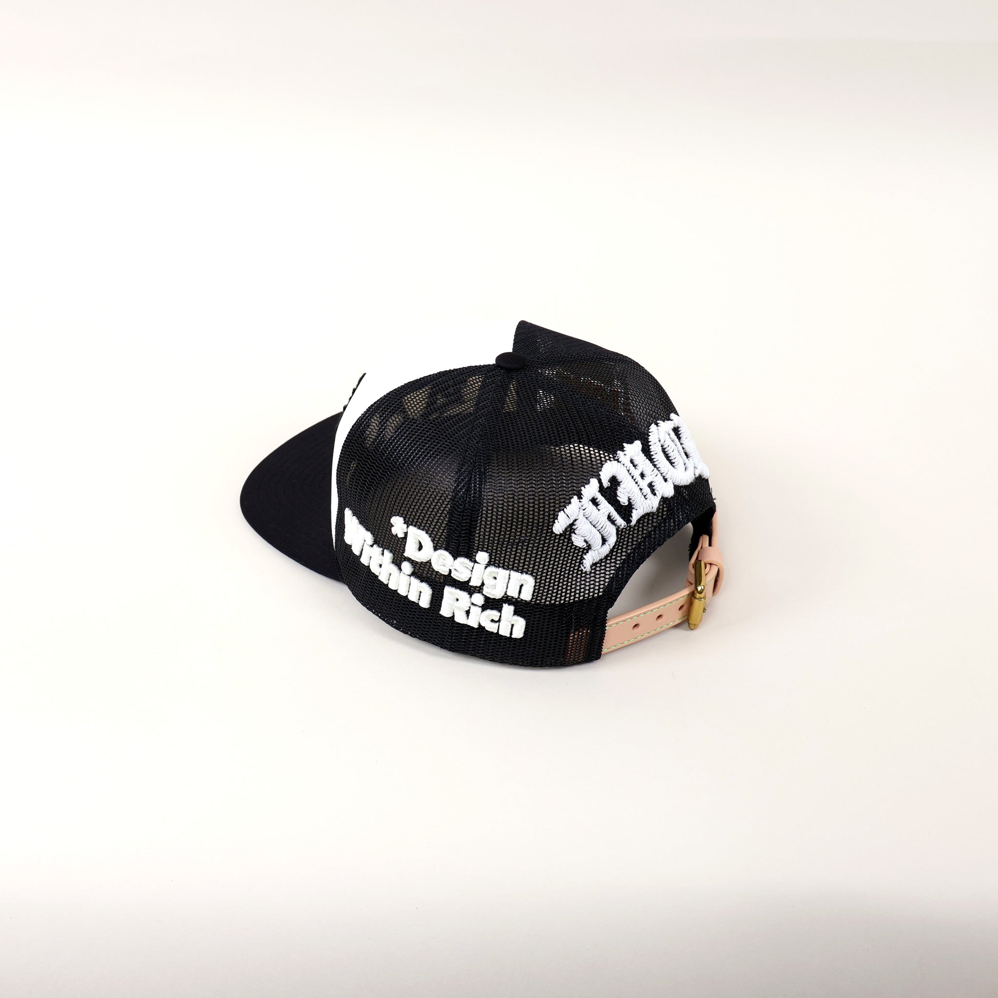Black mesh cap with white text and leather strap.