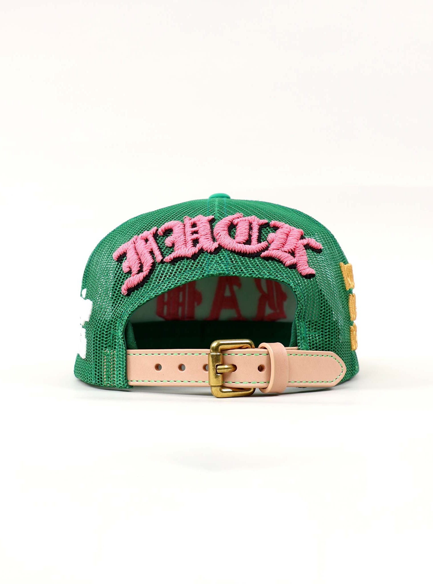 Green cap with pink embroidered text and buckle.
