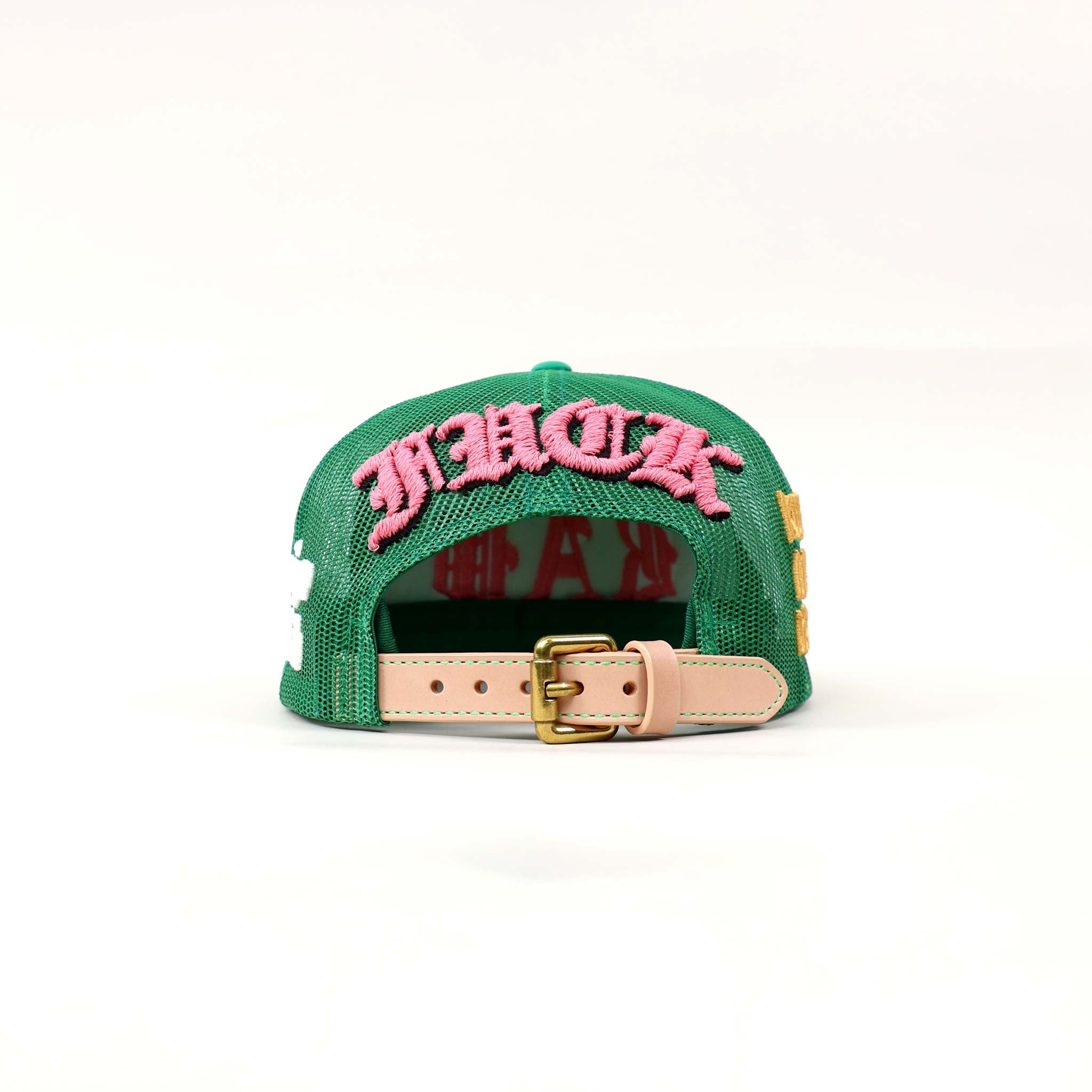 Green cap with pink embroidered text and buckle.