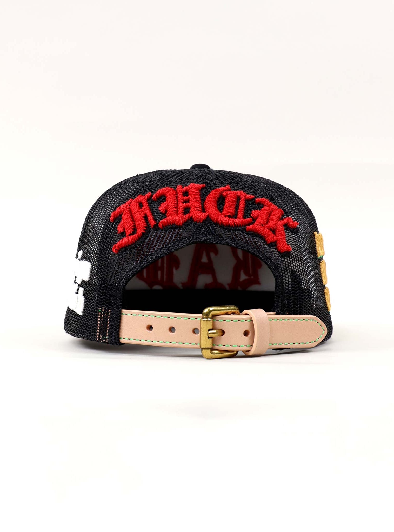 Black cap with red embroidered text, adjustable strap.