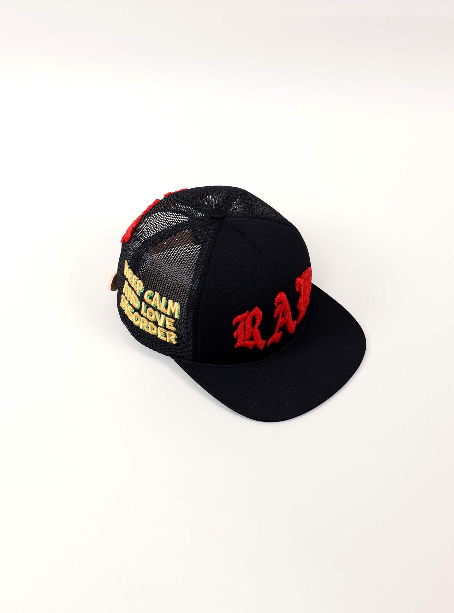 Black cap with red and yellow embroidery.