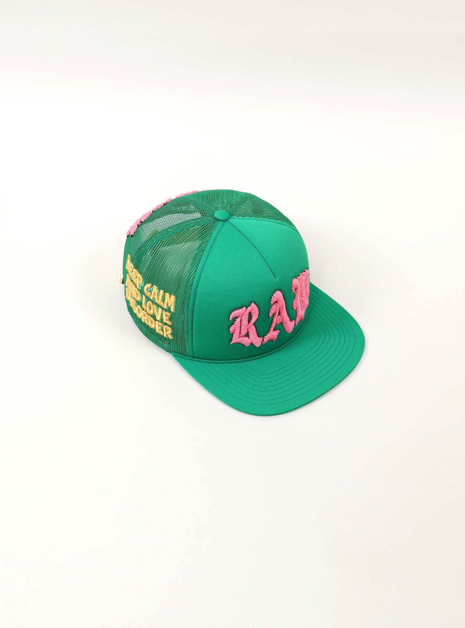 Green cap with pink and yellow embroidery.