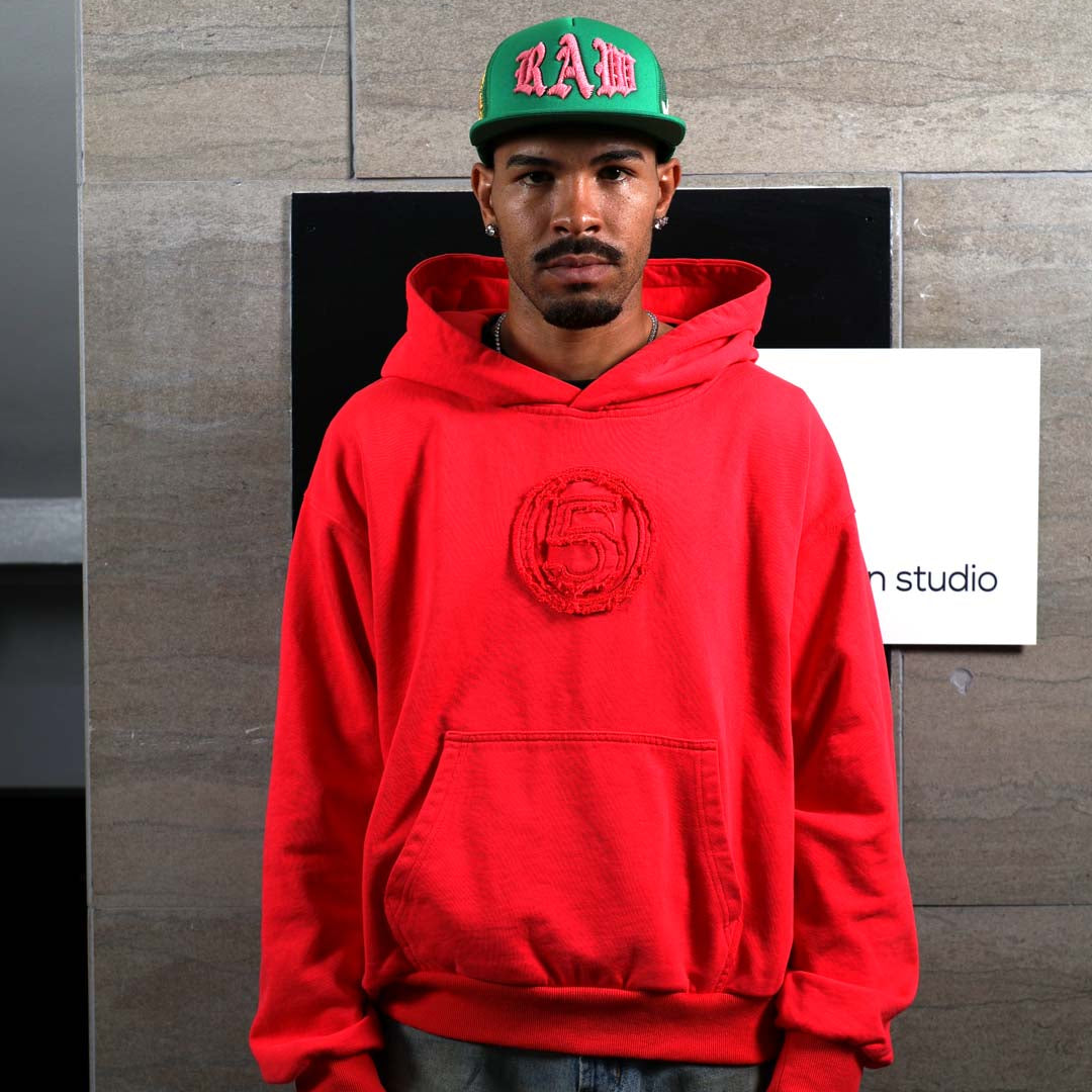 Man in red hoodie and green cap.