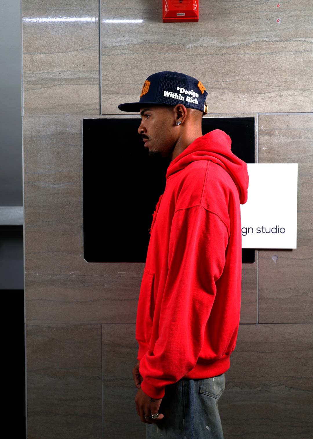 Person wearing a red hoodie and black cap