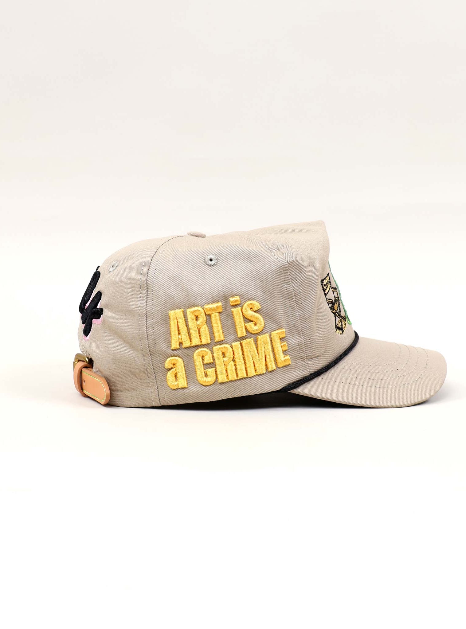 Beige cap with "Art is a Crime" text.