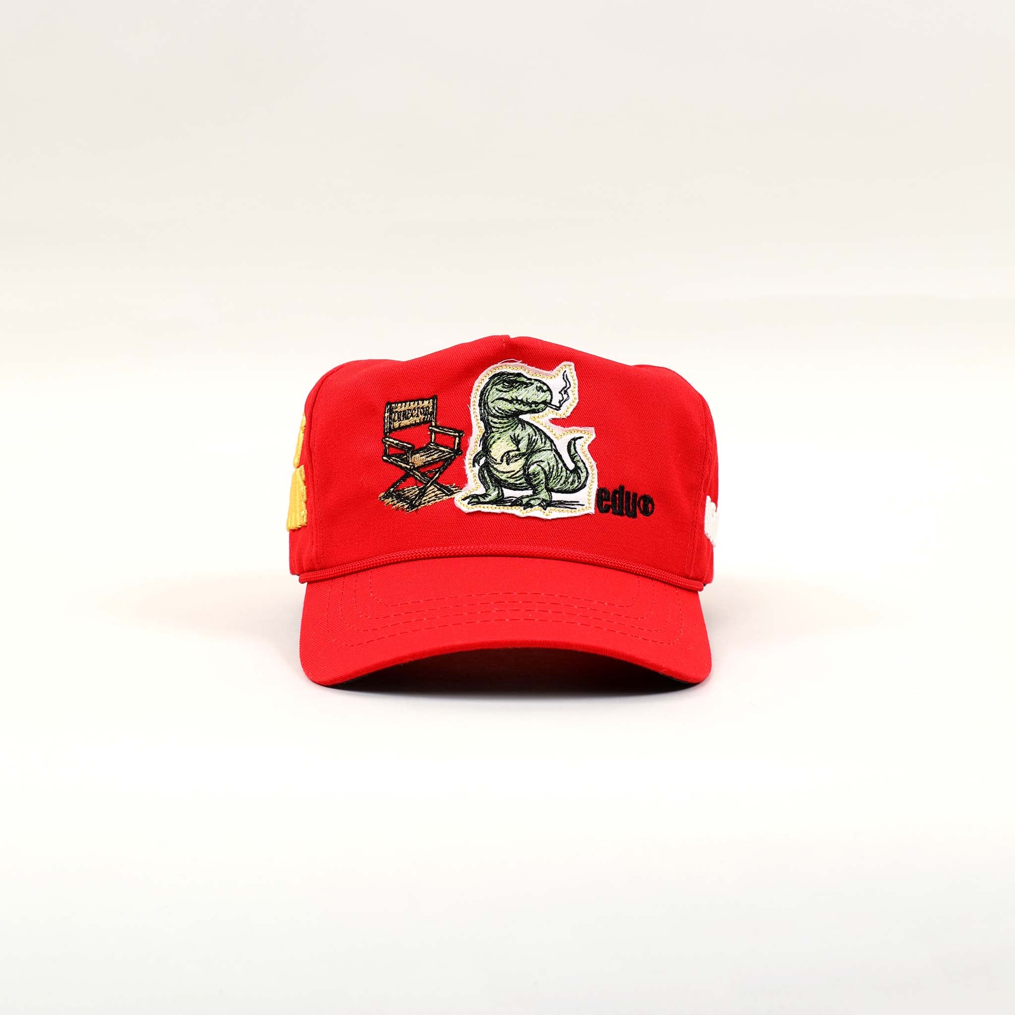 Red cap with dinosaur and educational patches.
