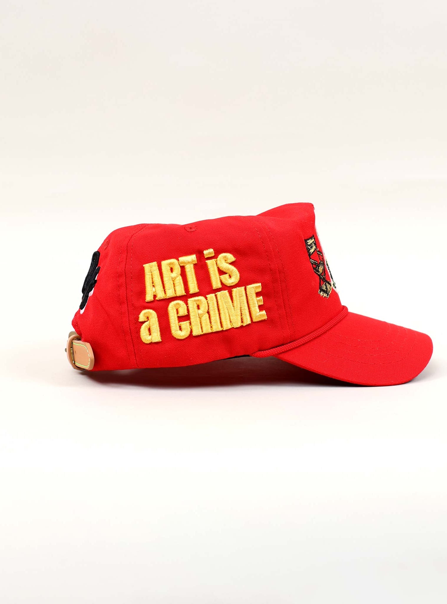 Red cap with "Art is a Crime" text.