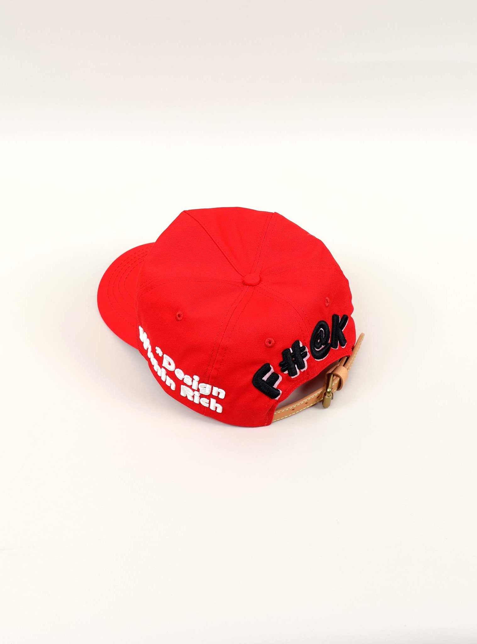 Red cap with embroidered text on the back.