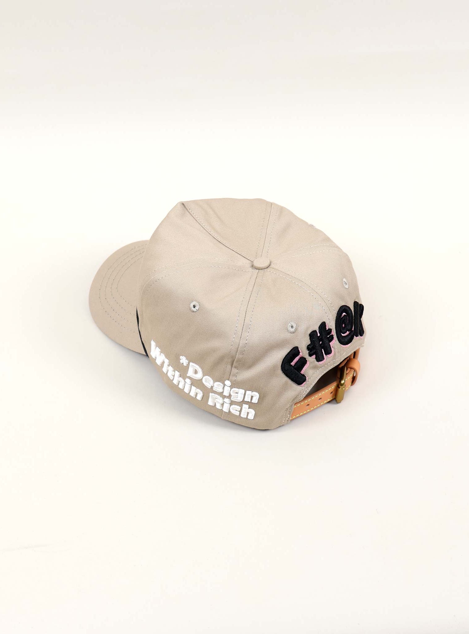 Beige cap with text design on back.