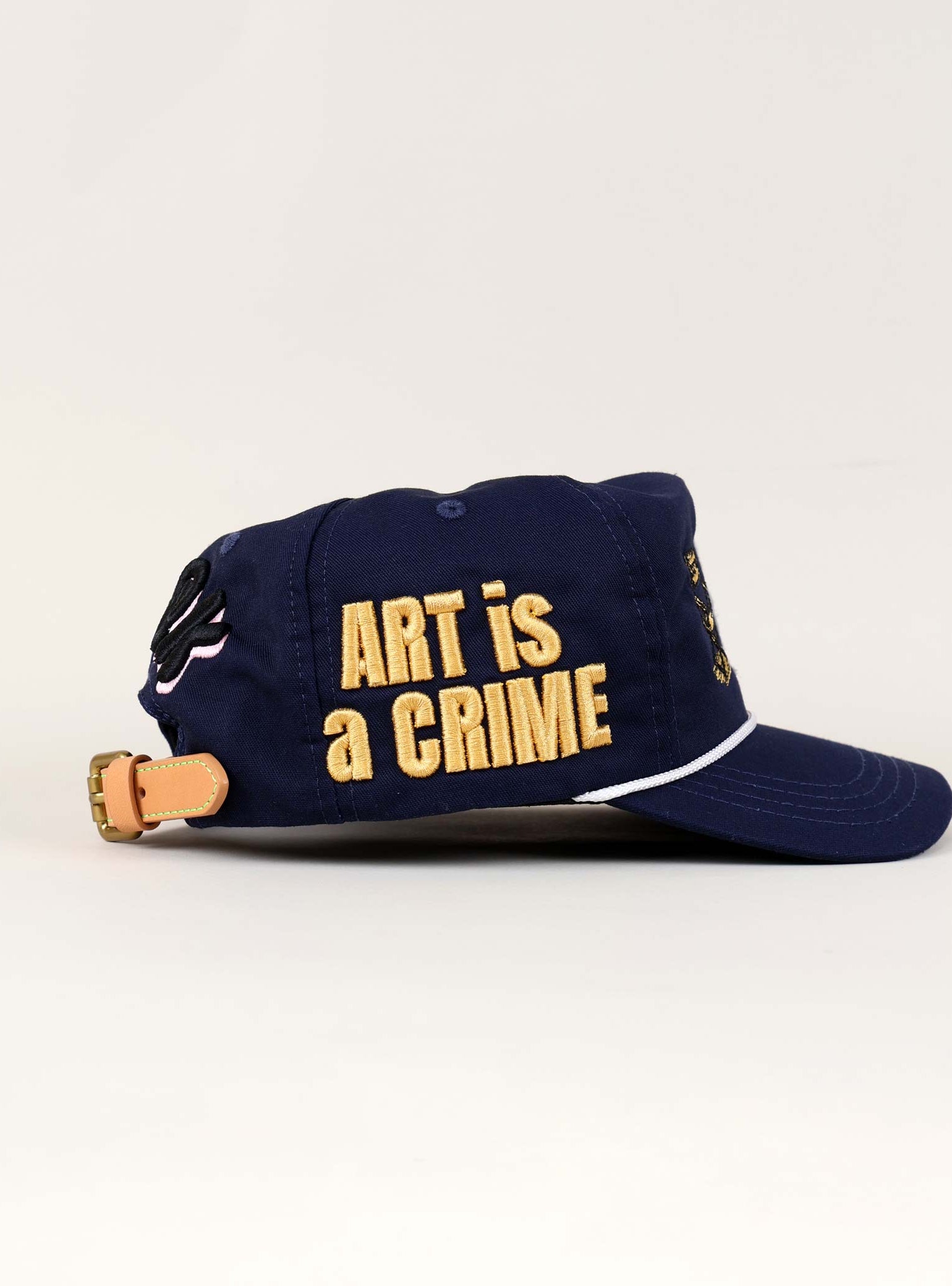 Blue cap with "ART is a CRIME" text.