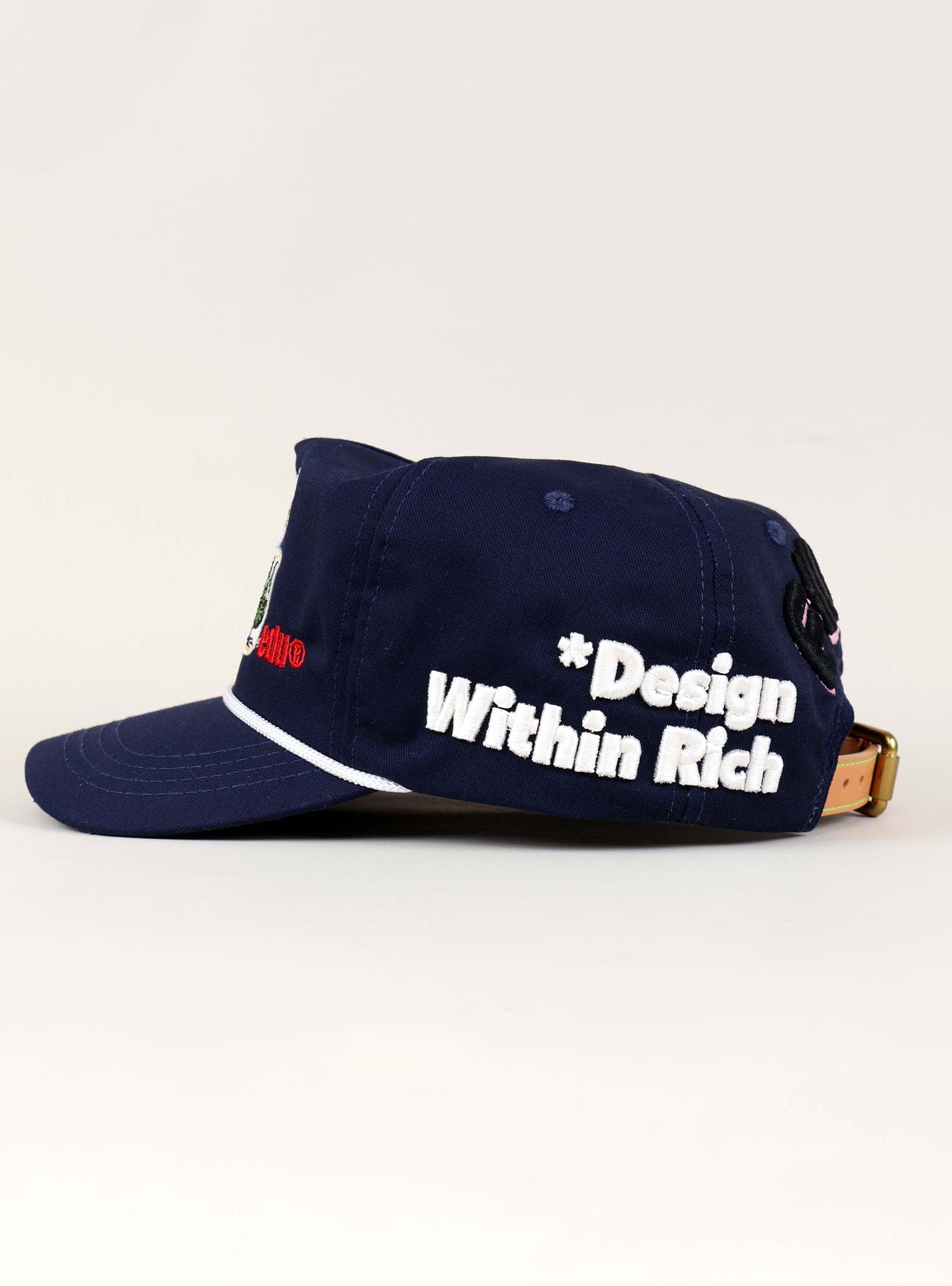 Navy cap with "Design Within Rich" text.