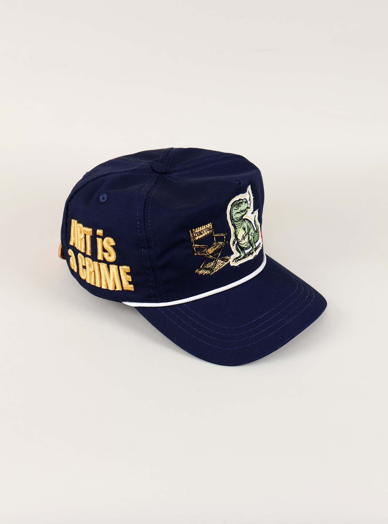 Navy cap with dinosaur and text embroidery.