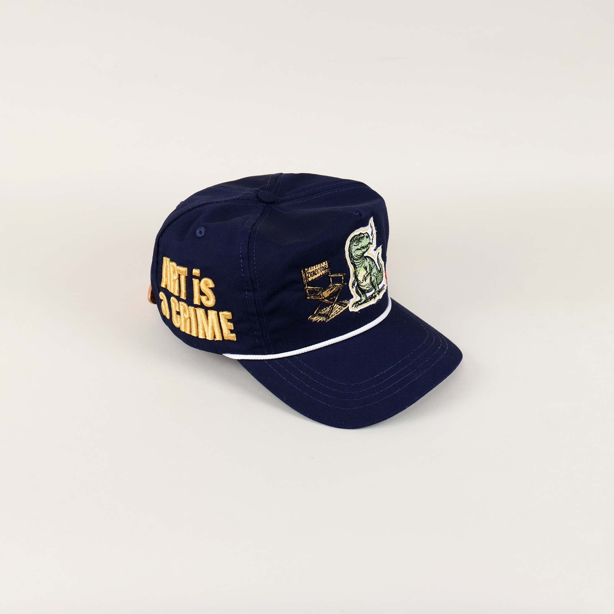 Navy cap with dinosaur and text embroidery.