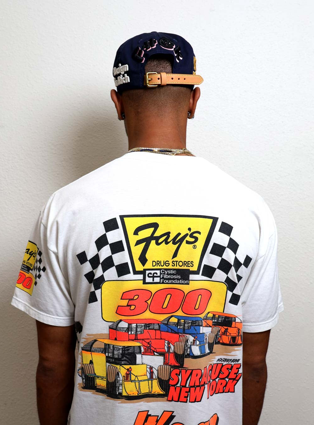 Man wearing racing-themed T-shirt and cap.