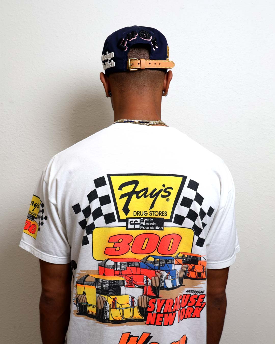 Man wearing racing-themed T-shirt and cap.