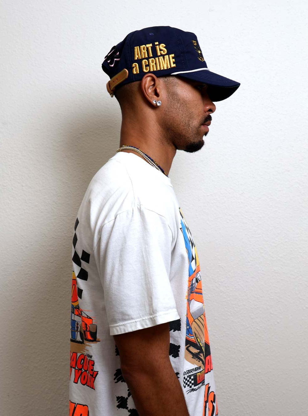 Man in graphic tee and cap, side profile.